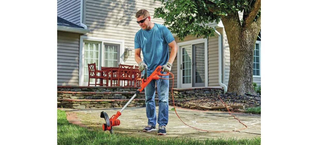 Man using Black and Decker Electric String Trimmer in yard