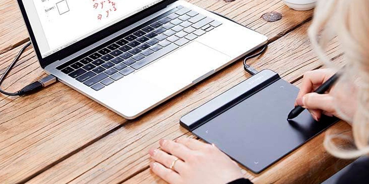 Person drawing on XP-Pen Star G640 in front of laptop computer Person drawing on XP-Pen Star G640 in front of laptop computer