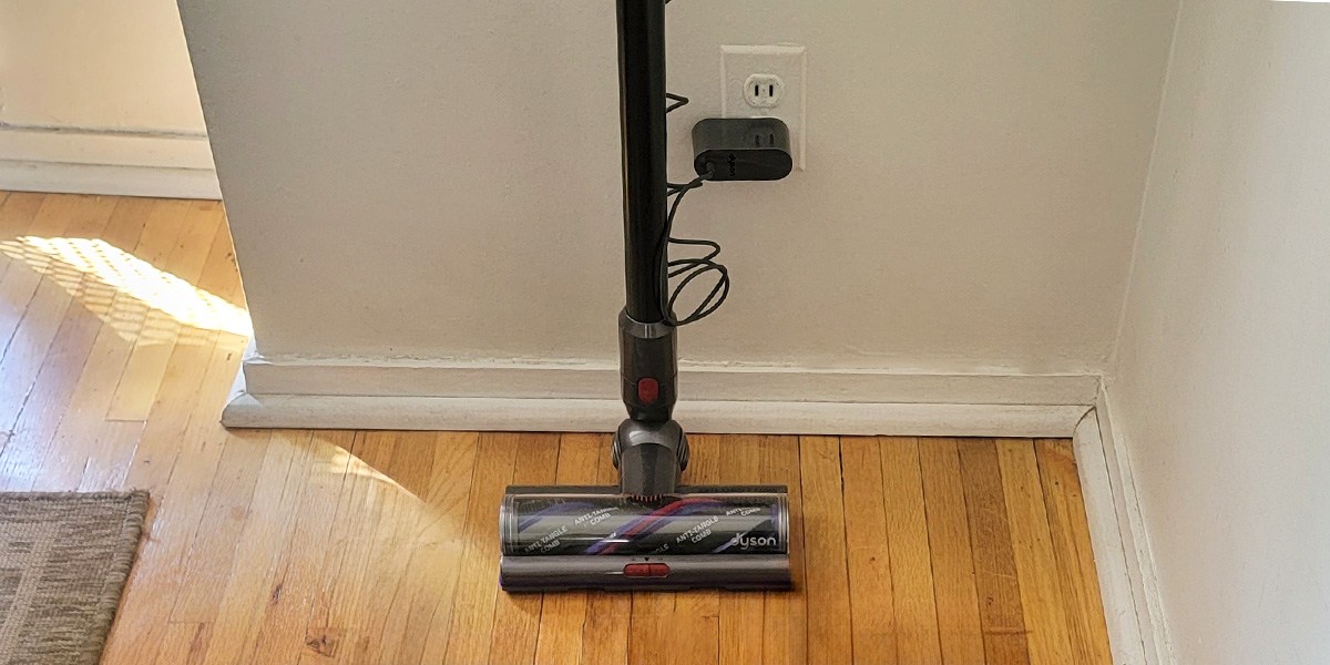 Dyson V15 Detect on hardwood floor leaning against wall Dyson V15 Detect on hardwood floor leaning against wall