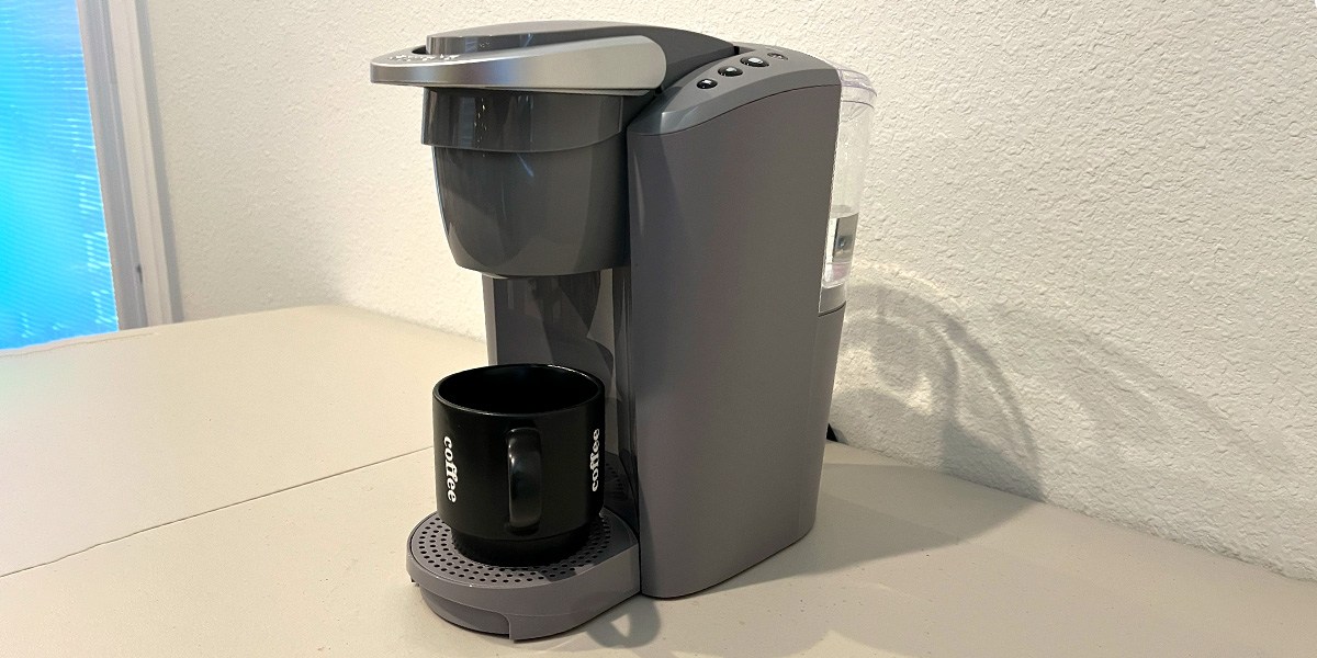 Keurig K-Compact Single-Serve K-Cup Pod Coffee Maker on counter with black cup Keurig K-Compact Single-Serve K-Cup Pod Coffee Maker on counter with black cup