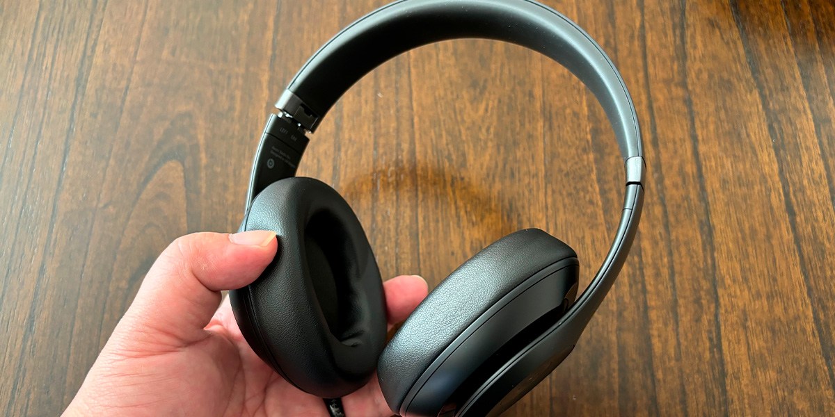 Hand holding over-ear headphones