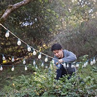 a man setting up string lights outdoors
