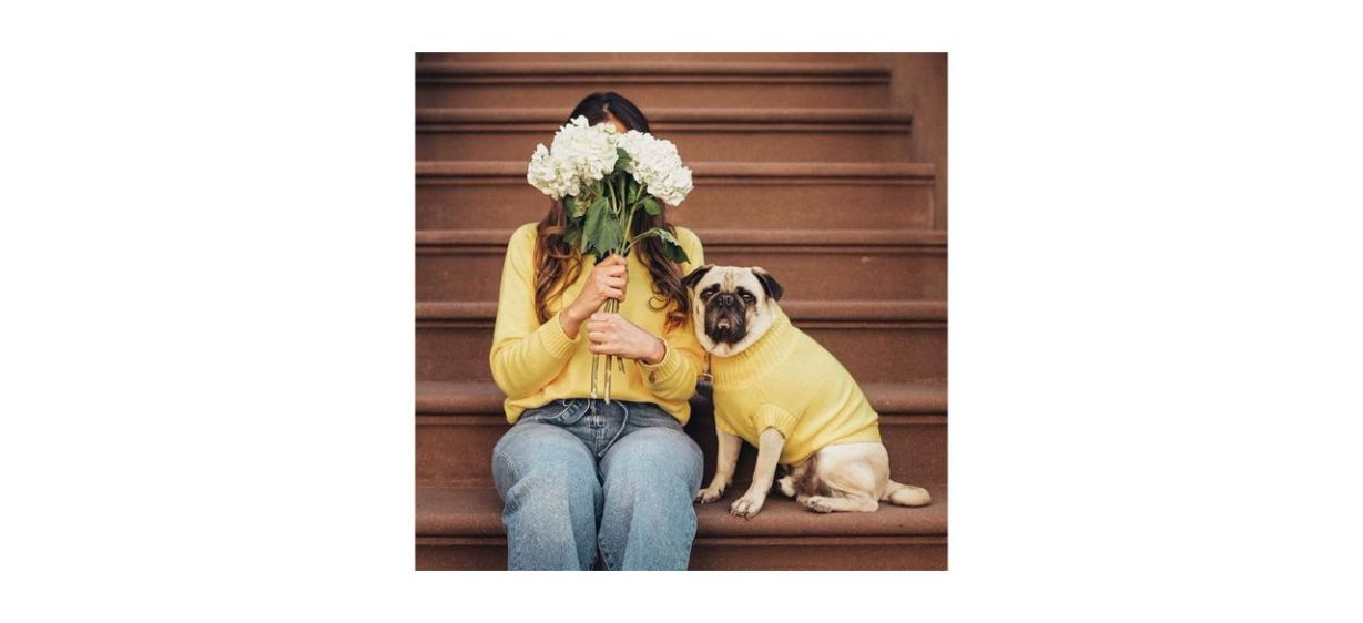 Woman and dog wearing matching yellow knit sweaters