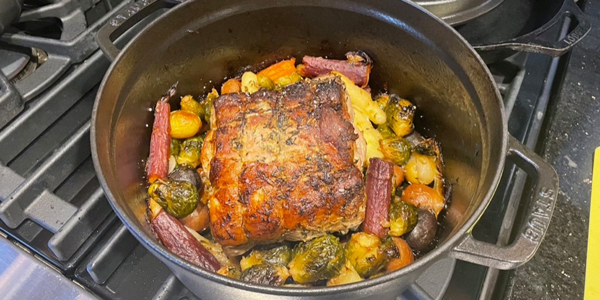 Silver Staub Cast Iron Dutch Oven on stove birner with food inside