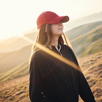 a woman wearing a red baseball cap